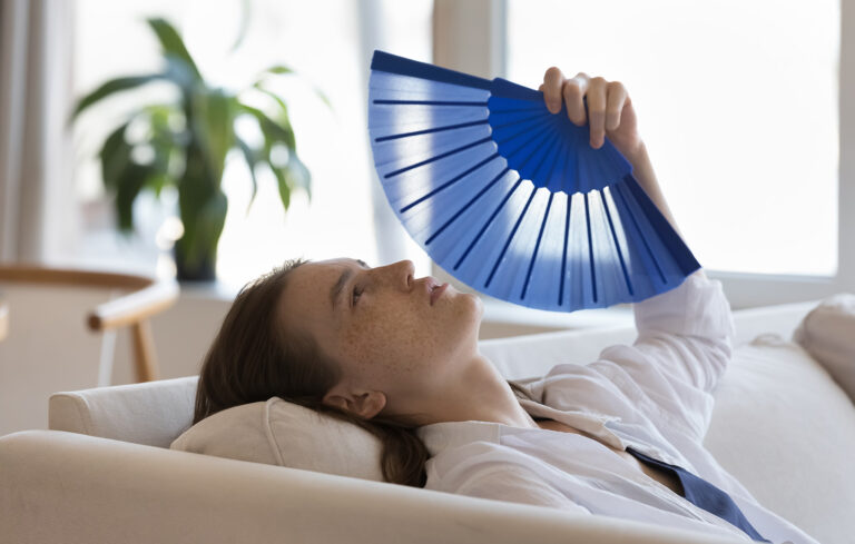 Kvinna som håller i en solfjäder.