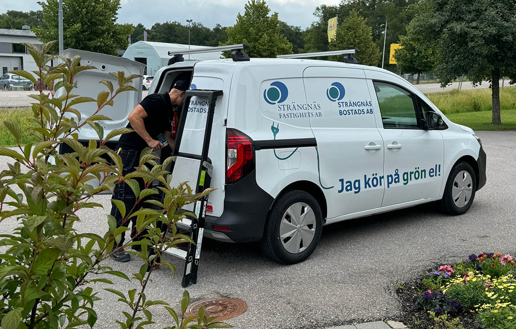 Fastighetstekniker plockar ut arbetsverktyg ur en skåpbil.