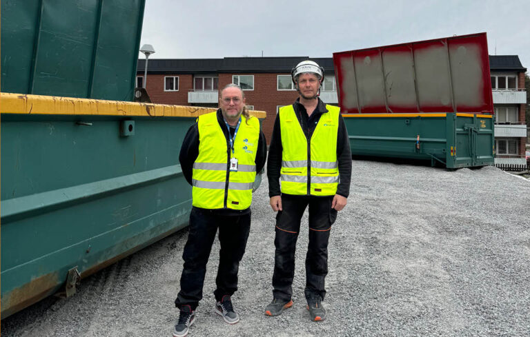 Personal ståendes framför en container.